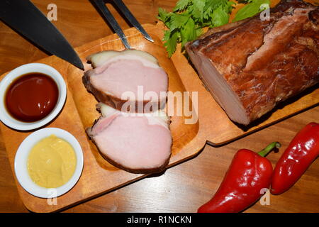 Kassler auf Holz rustikale Platte. Es ist oft mit Sauerkraut und Kartoffelpüree serviert. Vollständig ausgehärtet und geräuchertem Schweinefilet Koteletts auf einer hölzernen Fach gekocht Stockfoto