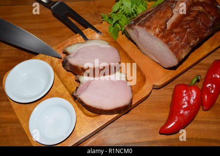 Kassler auf Holz rustikale Platte. Es ist oft mit Sauerkraut und Kartoffelpüree serviert. Vollständig ausgehärtet und geräuchertem Schweinefilet Koteletts auf einer hölzernen Fach gekocht Stockfoto