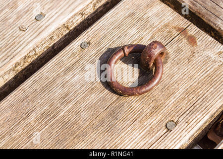 Altes rostiges Metall dock Ring auf einem hölzernen Pier Stockfoto