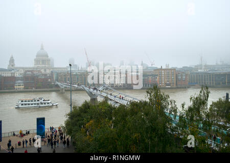 London, UK, 30. Oktober 2016: ein Blick auf die Themse und London Millennium Fußgängerbrücke in Richtung St. Pauls Kathedrale und die Innenstadt von London an einem nebligen Herbsttag Stockfoto