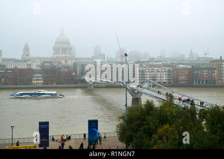 London, UK, 30. Oktober 2016: ein Blick auf die Themse und London Millennium Fußgängerbrücke in Richtung St. Pauls Kathedrale und die Innenstadt von London an einem nebligen Herbsttag Stockfoto