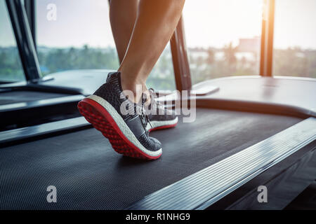 Männliche Füße in Turnschuhen auf dem Laufband im Fitnessstudio. Übung Konzept. Stockfoto