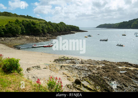 Helford Passage, Großbritannien - 8. Juni 2017: Auf der Suche die malerische Helford Mündung, wo viele kleine Boote in der Nähe des ländlichen Helford Passage, Cornwall, UK vor Anker liegen. Die Helford River ist eine Ria (überfluteten Fluss Tal) sowie ein Reiseziel in der Cornwall bekannt Stockfoto