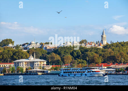 Ein Ausflugsboot Transite das Wahrzeichen Sepetçiler Palace in Sarayburnu. Topkapi Palast auf der Rückseite Istanbul, Türkei Stockfoto