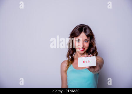 Frau mit weißem Papier mit Text tun es. Startup junge Frau mit Papier Hinweis Ich kann positive Haltung und Ermutigung, motivierendes Konzept. Platz kopieren. Frau Power concept. Stockfoto