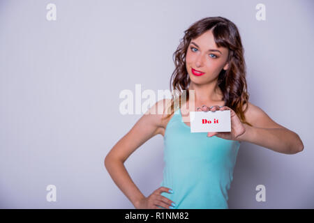 Frau mit weißem Papier mit Text tun es. Startup junge Frau mit Papier Hinweis Ich kann positive Haltung und Ermutigung, motivierendes Konzept. Platz kopieren. Frau Power concept. Stockfoto