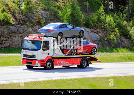 Paimio, Finnland - 1. Juni 2018: Volvo Abschleppwagen Abschleppwagen von hinaus Sjoberg Transporte zwei neue Autos auf der Autobahn im Sommer im Süden Finnlands. Stockfoto