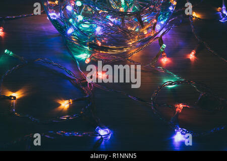 Weihnachtsbeleuchtung innen eine Kristallkugel auf einem hölzernen Hintergrund. Weihnachtsdekoration Stockfoto