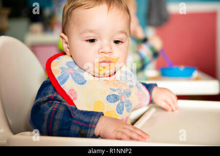 Ein Baby Kind isst Essen im Kindergarten Stockfoto