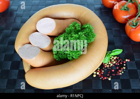 Lyoner ist eine Wurst Feinkost auf einem schwarzen Tischset. Lyoner ist ein wurst-delikatessen in einem schwarzen Tischset. Stockfoto