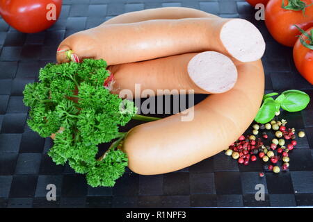 Lyoner ist eine Wurst Feinkost auf einem schwarzen Tischset. Lyoner ist ein wurst-delikatessen in einem schwarzen Tischset. Stockfoto