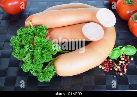 Lyoner ist eine Wurst Feinkost auf einem schwarzen Tischset. Lyoner ist ein wurst-delikatessen in einem schwarzen Tischset. Stockfoto