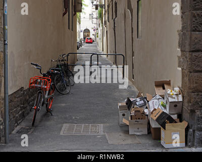 Zwei geparkte Fahrräder und einen Stapel von Kartons in einer sonst verlassene Straße in Florenz, Toskana, Italien Stockfoto