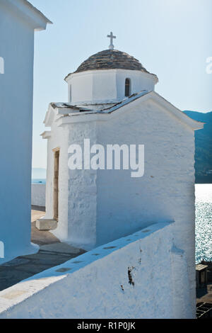 Kleine weiße Kirche auf einem Hügel über der Stadt Skopelos an Sommermorgen, Insel Skopelos, Griechenland Stockfoto