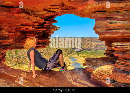 Kaukasische Frau im Rock arch im roten Sandstein von der Natur für Fenster, Blick auf den Murchison River im Kalbarri Nationalpark, Western Australia. Australien reisen Outback. Stockfoto