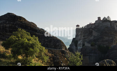 Die riesigen Felsen mit christlich-orthodoxen Klöster bei Sonnenuntergang über dem Tal in der Nähe von Meteora Kalambaka, Thessalien, Griechenland Stockfoto