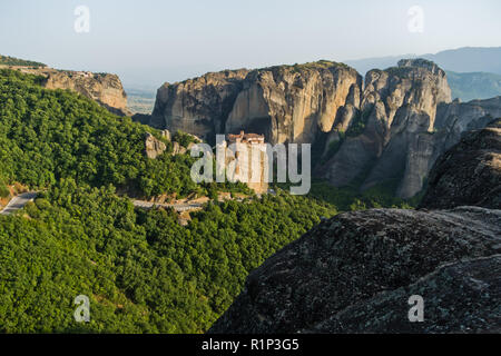 Die riesigen Felsen mit christlich-orthodoxen Klöster bei Sonnenuntergang über dem Tal in der Nähe von Meteora Kalambaka, Thessalien, Griechenland Stockfoto