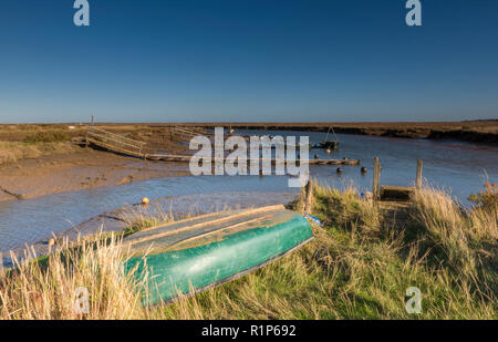 Morston Kai und Creek in atmosphärischen North Norfolk. Kleine Boote auf alte hölzerne Stege und Pontons auf einem hellen herbstlichen Tag günstig Stockfoto