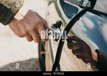 Nahaufnahme eines Menschen Hand öffnet die Tür mit einem Schlüssel. Stockfoto