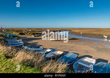 Morston Kai und Creek in atmosphärischen North Norfolk. Kleine Boote auf alte hölzerne Stege und Pontons auf einem hellen herbstlichen Tag günstig Stockfoto