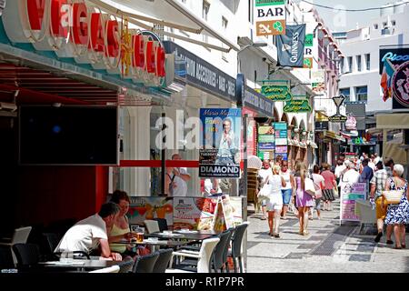 Touristen entspannen Sie in einem Cafe in der Altstadt mit Geschäften und Käufer auf der Rückseite, Albufeira, Algarve, Portugal, Europa. Stockfoto