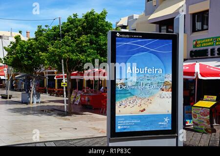 Straßencafés auf dem Hauptplatz in der Altstadt während der Morgen mit einer Werbetafel im Vordergrund, Albufeira, Algarve, Portugal, Europa Stockfoto