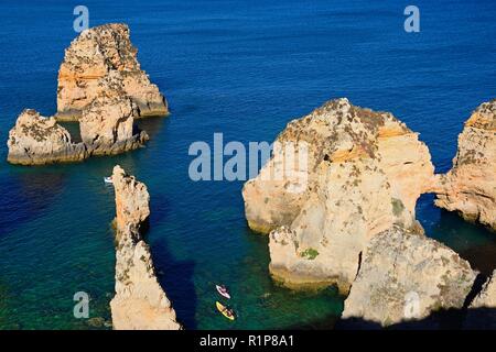 Erhöhte Sicht auf die Klippen mit einem Touristen in Kanus in der Bucht, Ponta da Piedade, Lagos, Algarve, Portugal, Europa. Stockfoto