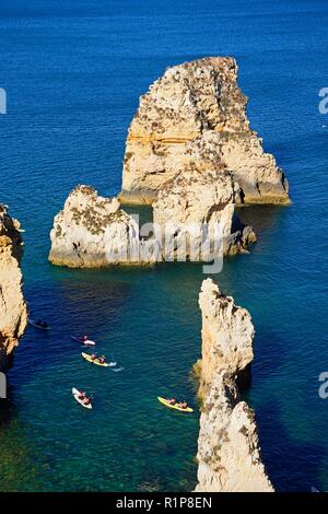 Erhöhte Sicht auf die Klippen im Ozean mit Touristen in Kajaks in der Bucht, Ponta da Piedade, Lagos, Algarve, Portugal, Europa. Stockfoto