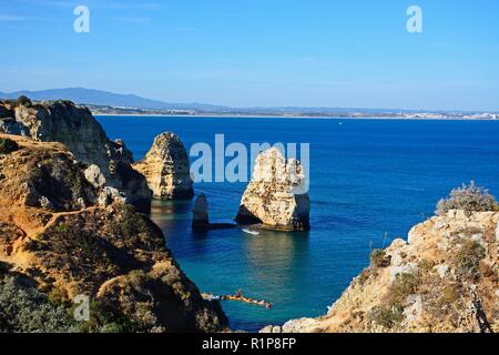 Erhöhte Sicht auf die Klippen im Ozean mit Touristen in Kajaks in der Bucht, Ponta da Piedade, Lagos, Algarve, Portugal, Europa. Stockfoto