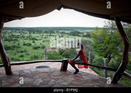 Eine Frau sieht in einem Abstand auf der Ebene von den Adler, in der Mara Naboisho Conservancy im Südwesten von Kenia, 3. Mai 2018 Lodge. Stockfoto