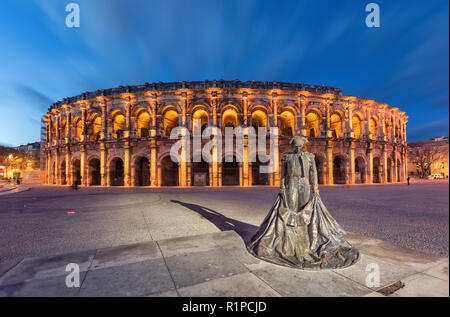 Nimes, Frankreich. Römische Amphitheater (Arena von Nimes) in der Abenddämmerung und Denkmal der Stierkämpfer Stockfoto