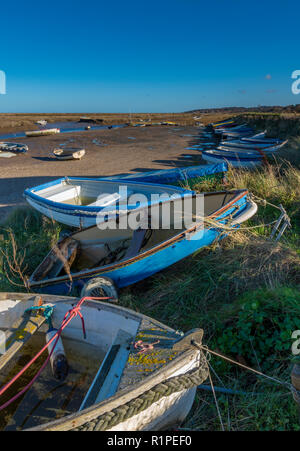 Morston Kai und Creek in atmosphärischen North Norfolk. Kleine Boote auf alte hölzerne Stege und Pontons auf einem hellen herbstlichen Tag günstig Stockfoto