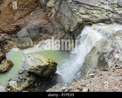 See Ngakoro Wasserfall, Wai-o-Tapu geothermischen Park, Neuseeland. Weiß dampfenden Spray fällt in eine bunte mineral Landschaft Stockfoto