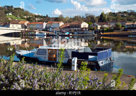 Am 28. März 2017 - SAINT-SYLVESTRE-sur-Lot, Frankreich: Boote im Frühjahr morgen Sonnenschein vertäut auf dem ruhigen Fluss Lot bei Saint-Sylvestre-sur-Lot, Lot-et-Garonne, Frankreich. Auf der anderen Seite des Flusses ist Port de Penne, dem alten Flusshafen für Penne d'Agenais Stadt. Stockfoto