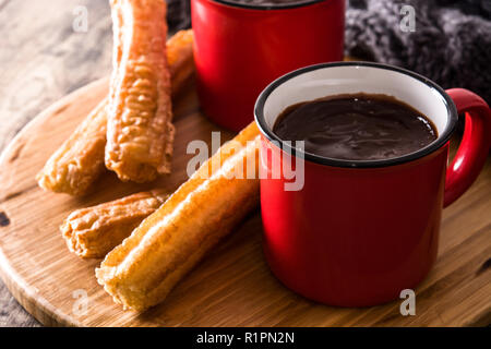 Heiße Schokolade mit churros auf hölzernen Tisch. Nahaufnahme Stockfoto