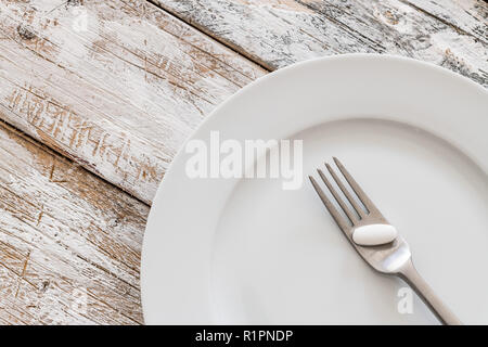 Tabletten mit silber Gabel auf einem alten Holztisch Stockfoto