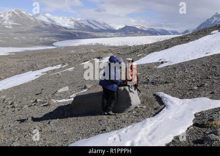 Wissenschaftler Aufzeichnung der GPS-Daten in Taylor Valley, McMurdo Dry Valleys, Antarktis, mit See Fryxell und Kanada Gletscher im Hintergrund Stockfoto