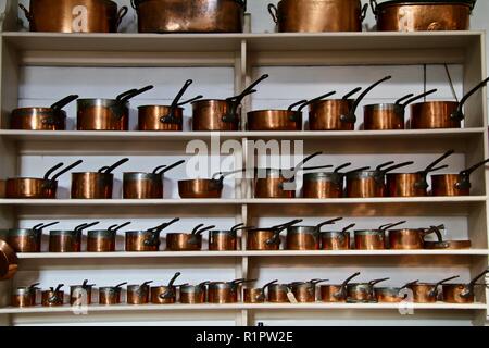 Ein Koch Küche mit Reihen von Kochen Kupfer Töpfe und Pfannen von klein bis groß Stockfoto