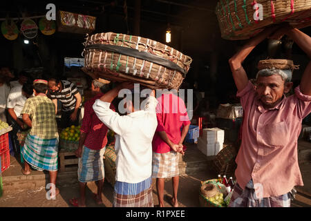 Torhüter in der Crawford Markt, Mumbai, Indien, jetzt offiziell genannt Mahatma Jyotiba Phule Mandai, Balance Ihre "palti' oder Körbe über ihren Köpfen Stockfoto