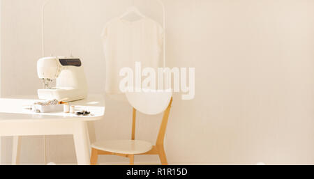 Arbeitsplatz zum Nähen und Handarbeit in einem hellen Raum mit weißen Möbeln. Bewegungsunschärfe und selektiven Fokus. Stockfoto