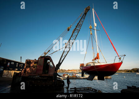 Boot/Yacht ist aus dem Fluß Deben hob mit einem Kran für die Lagerung im Winter in Woodbridge, Suffolk bereit Stockfoto