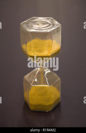 Sanduhr am rustikalen Holztisch. Die Zeit wird knapp oder Termin Konzept. Nahaufnahme Stockfoto