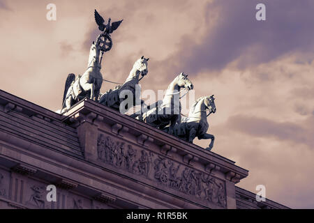 Die Quadriga des Brandenburger Tor gegen einen bewölkten Himmel in Berlin, Deutschland bei Sonnenuntergang Stockfoto