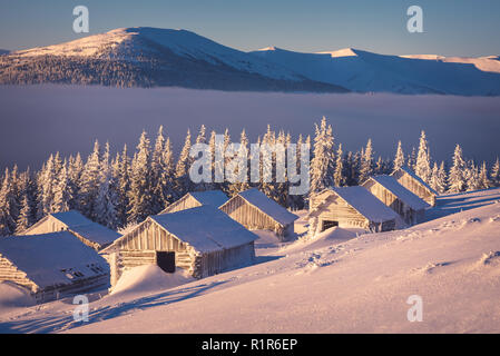 Winterlandschaft mit Holzhäuser in den Bergen. Sonnigen morgen. Das Dorf der Hirten Stockfoto