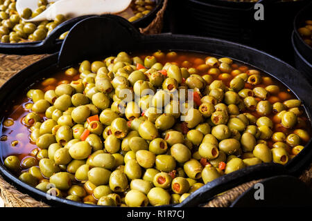 Körbe mit Oliven gefüllt mit rotem Pfeffer für den Verkauf in einem Markt Stockfoto