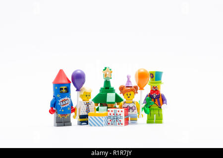 Lego minifigur Junge, Mädchen, Clown und Feuerwerk Anzug Kerl mit Weihnachtsbaum und Geschenkverpackung. Lego Minifiguren sind von der Lego Gruppe hergestellt. Stockfoto