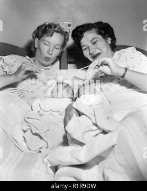 Zwei neue Mütter überprüfen Sie die Temperatur Ihres Babys, Ca. 1960. Stockfoto