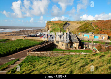 Auf die Torhüter Cottage und die Toilette/shop Block und Parkplatz mit dem Felsen übersäten Strand und Klippen in der Dunraven Bay. Stockfoto