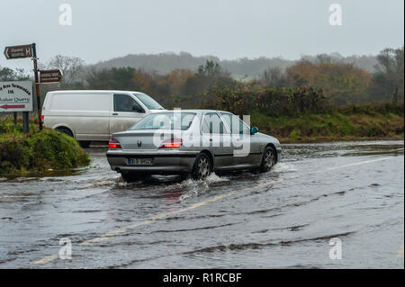 Dunmanway, West Cork, Irland. 14 Nov, 2018. Ein Auto verhandelt eine schlecht überschwemmte Straße gerade außerhalb Dunmanway nach einer Nacht von sintflutartigen Regenfällen. Der Tag wird sehr nass und windig mit Höhen von 13 bis 15°C. Credit: Andy Gibson/Alamy Leben Nachrichten. Stockfoto