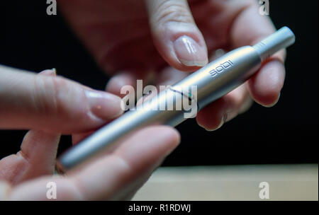 Hamburg, Deutschland. 14 Nov, 2018. Ein Mitarbeiter der Philip Morris GmbH zeigt ein neues Modell der Tabak Verdampfer iqos auf einer Pressekonferenz der Tabakunternehmen. Die Presse Konferenz konzentrierte sich auf die Marktdurchdringung der Tabak Verdampfer' iqos' und der Präsentation der neuen Ausrüstung. Quelle: Axel Heimken/dpa/Alamy leben Nachrichten Stockfoto